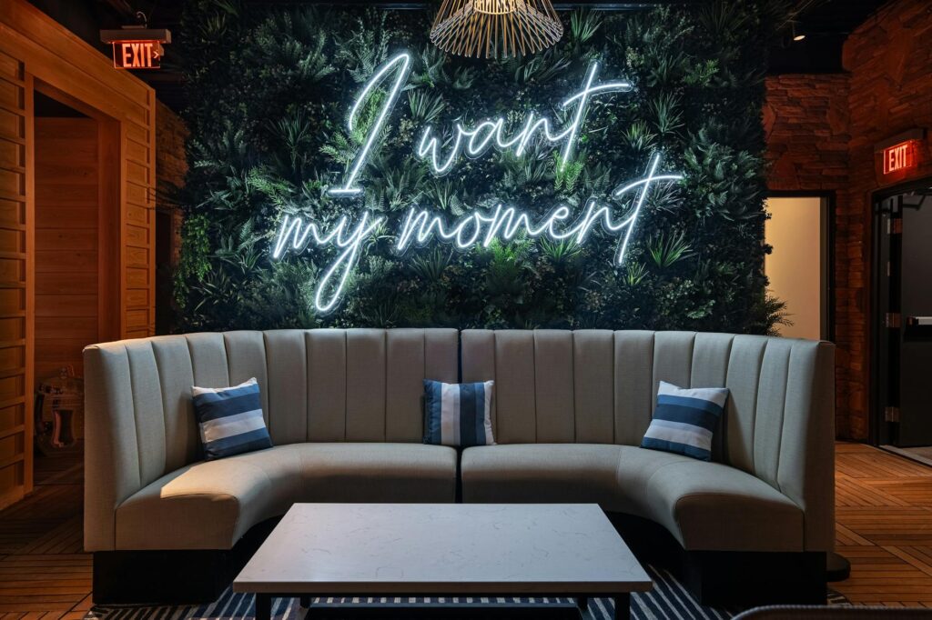 sofa and coffee table by a wall with a neon writing